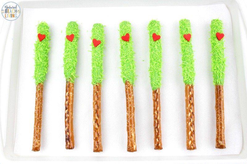 These delicious Grinch Chocolate Covered Pretzels will make everyone happy. They are so easy to make and Grinch Food Recipes look great on a party table. Add these Grinch Chocolate Covered Pretzels to your Grinch Food list and pull off a marvelous movie night or holiday party, Chocolate dipped pretzels, Grinch Party Ideas