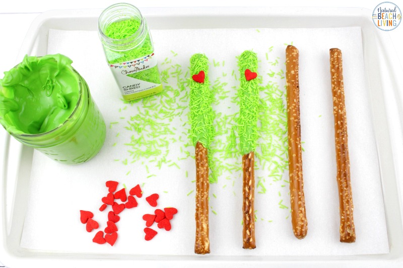These delicious Grinch Chocolate Covered Pretzels will make everyone happy. They are so easy to make and Grinch Food Recipes look great on a party table. Add these Grinch Chocolate Covered Pretzels to your Grinch Food list and pull off a marvelous movie night or holiday party, Chocolate dipped pretzels, Grinch Party Ideas
